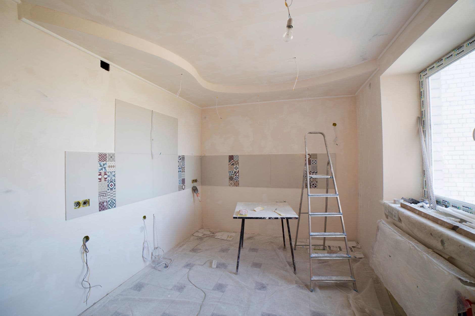 Kitchen renovation in progress with ladder and tools on site.