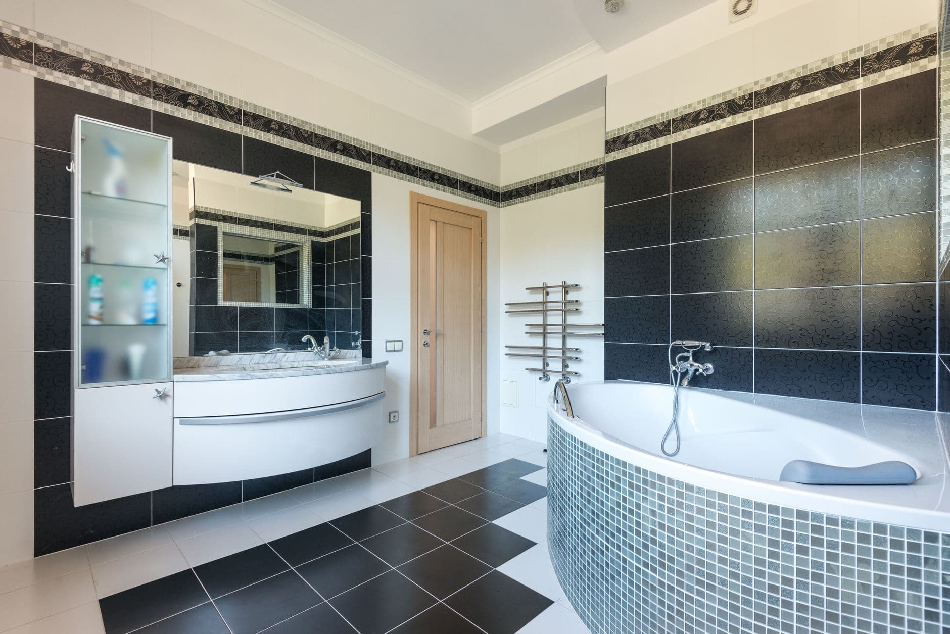 Modern bathroom interior with black and white tile walls and finishes.